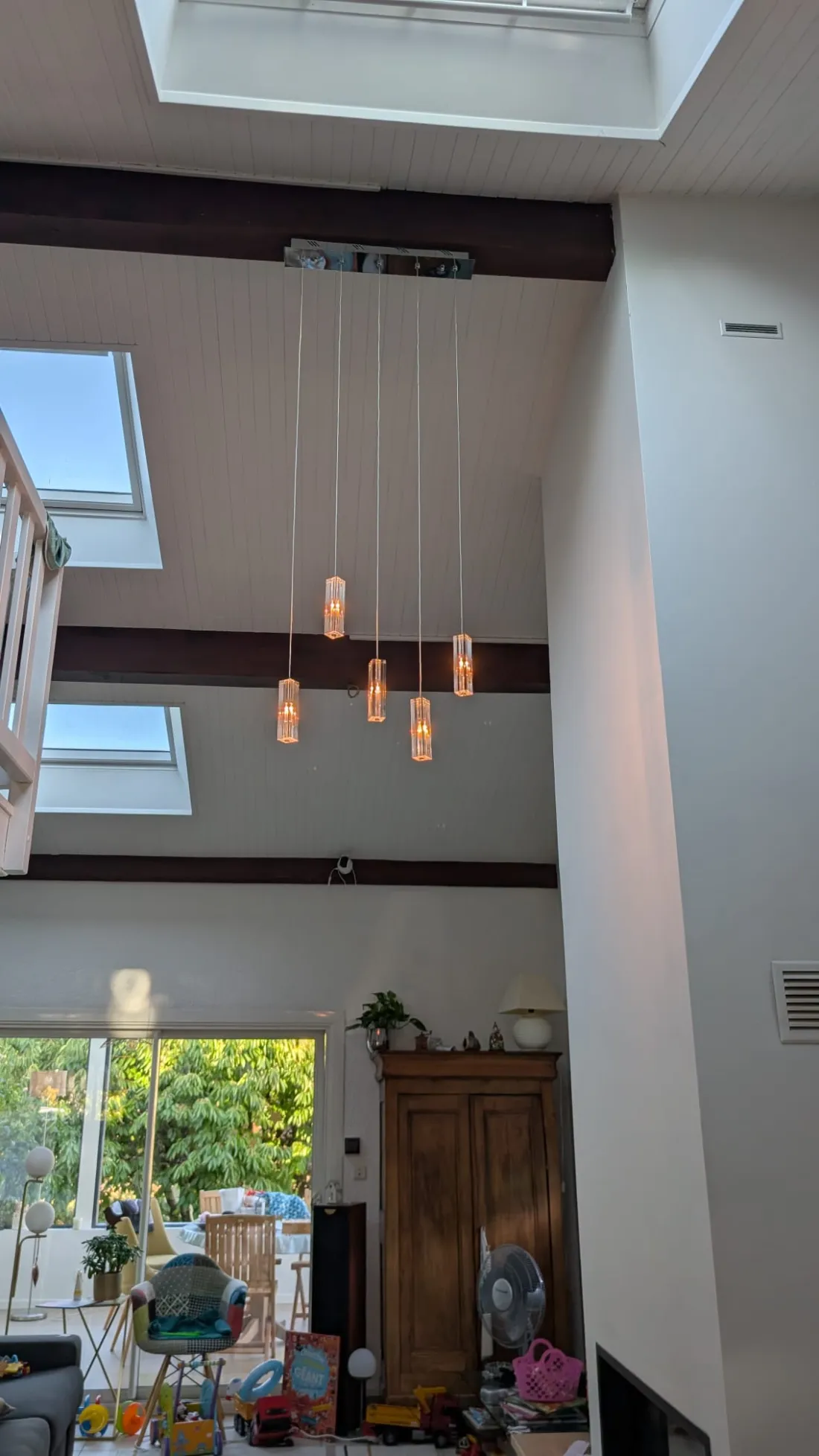 Suspension à cinq pendants installée dans un séjour à double hauteur à Aix-les-Bains