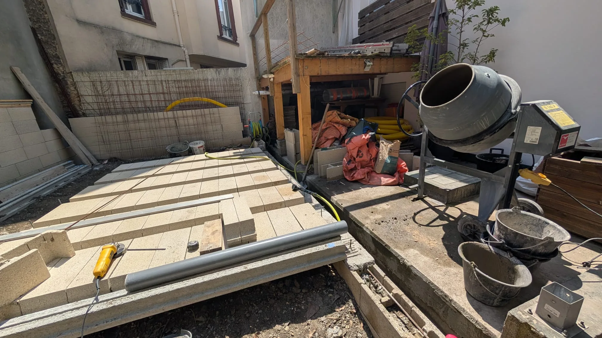 Hourdis mis en place entre les poutrelles formant le support de la terrasse, bétonnière à côté