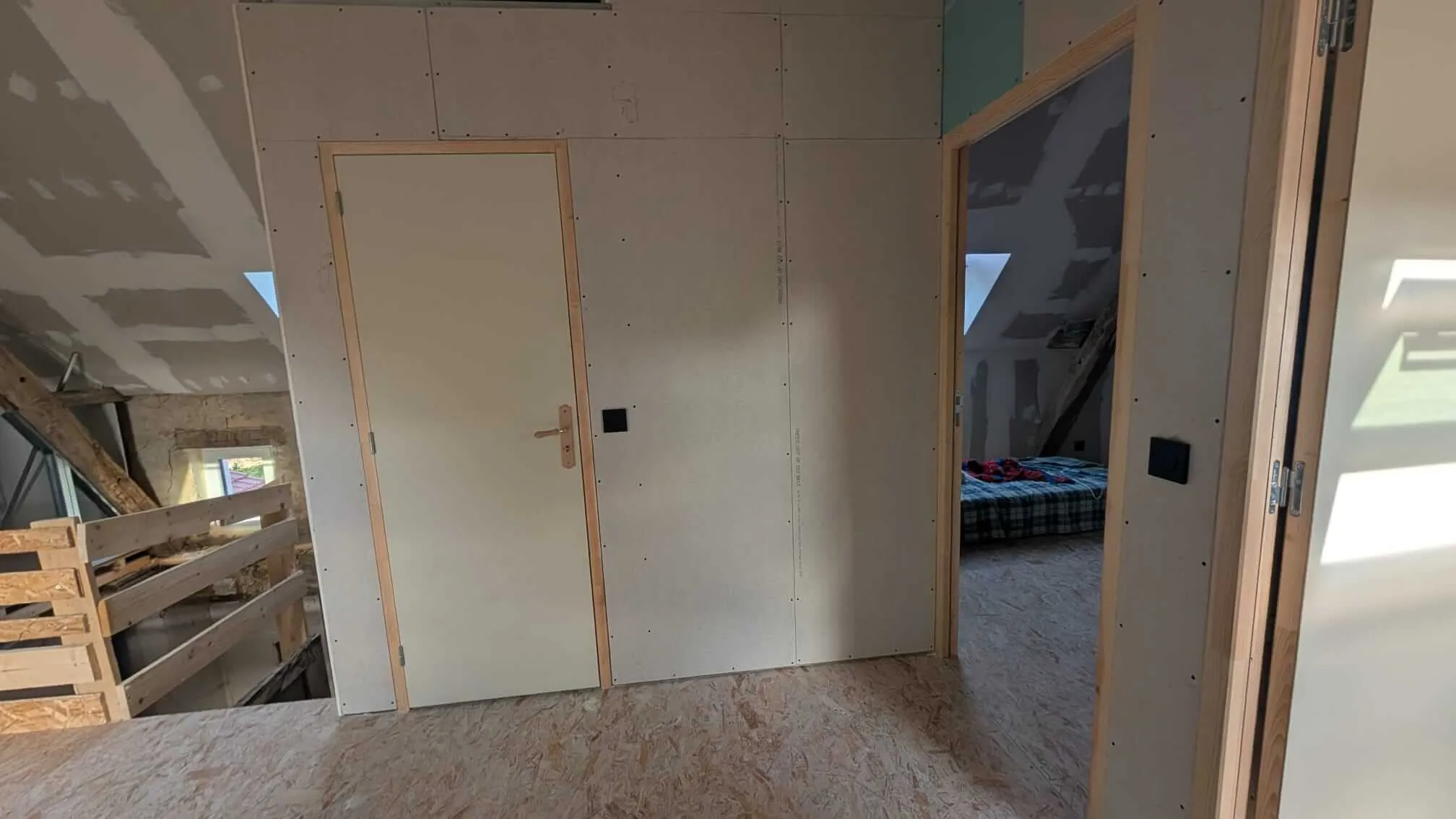 La porte pleine de la salle de bain posée, vue depuis le palier